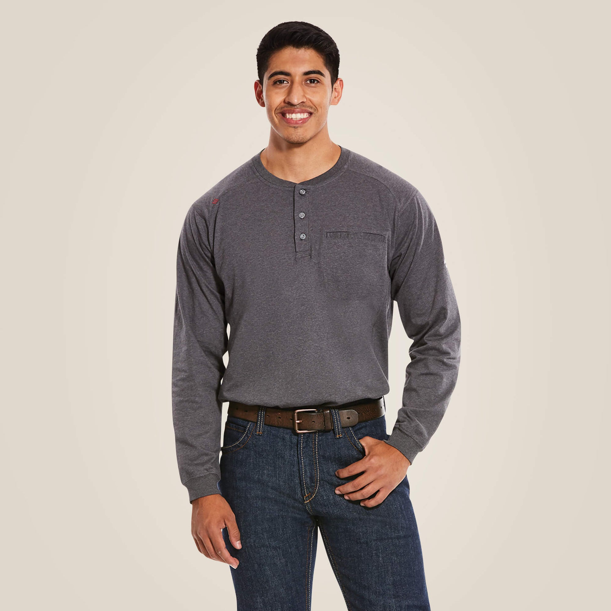 A man wearing a grey Ariat FR Henley shirt