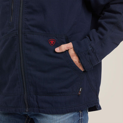 A man wearing blue Ariat stretch FR jacket zoomed in to pocket area