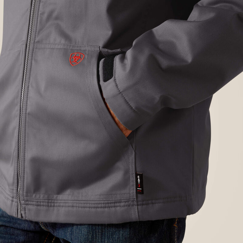 Close up of a man wearing Ariat FR insulated jacket in grey showing pockets
