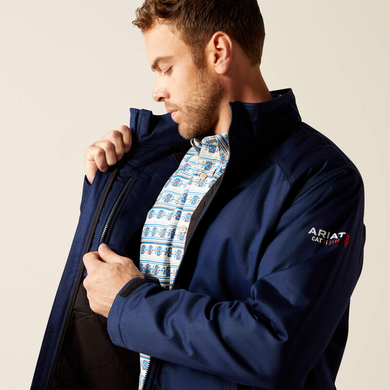 Close up of a man wearing Ariat FR insulated jacket in navy showing inner pocket