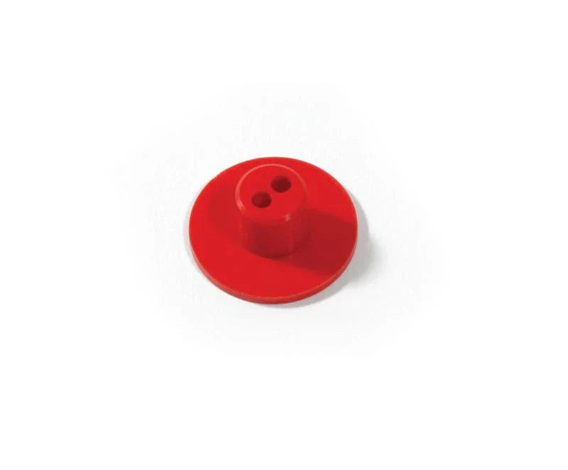 Red plastic button with two holes on a white background